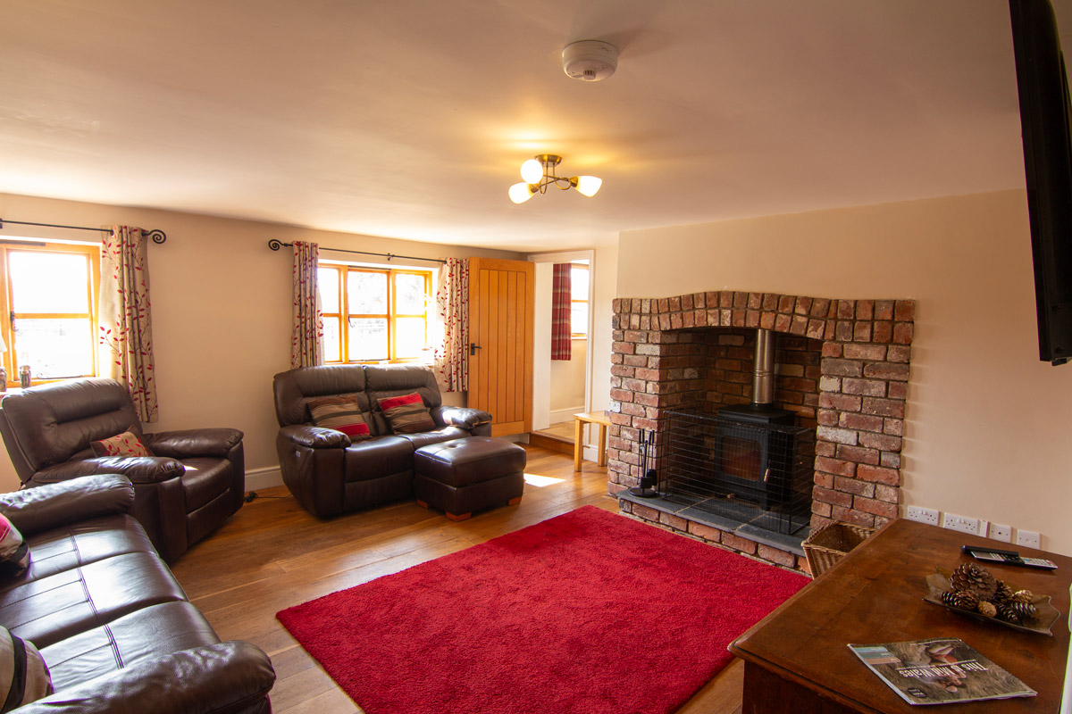 Living Room: “Cozy living room at Colstey Farmhouse featuring comfortable seating, a warm fireplace, and elegant decor.”